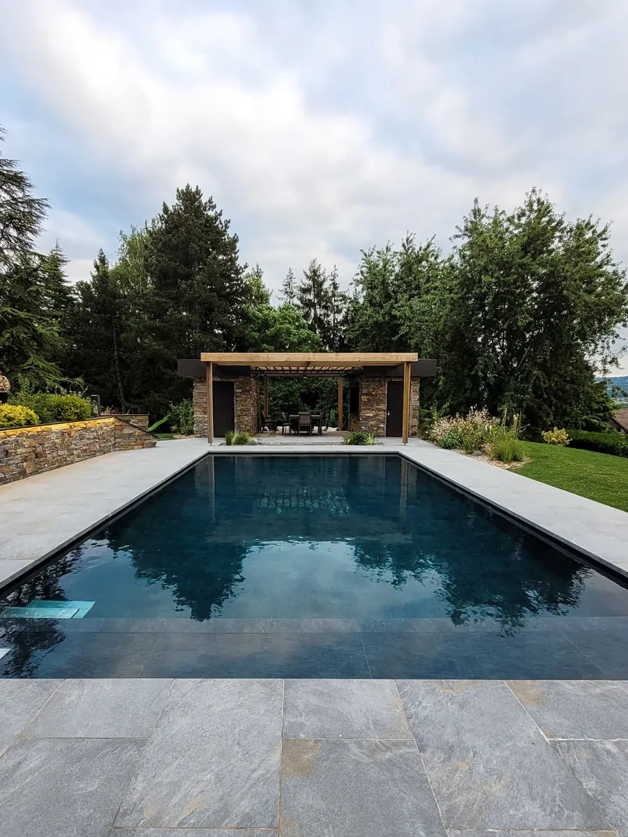 Après : piscine rénovée avec terrasse en pierre, pergola et jardin aménagé