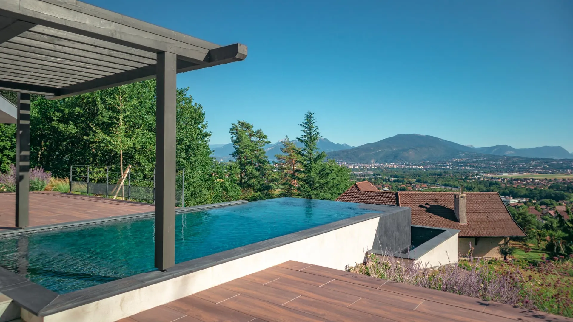 Piscine à débordement sous pergola, terrasse en bois et vue sur les montagnes à Pringy, projet Atelier Olea