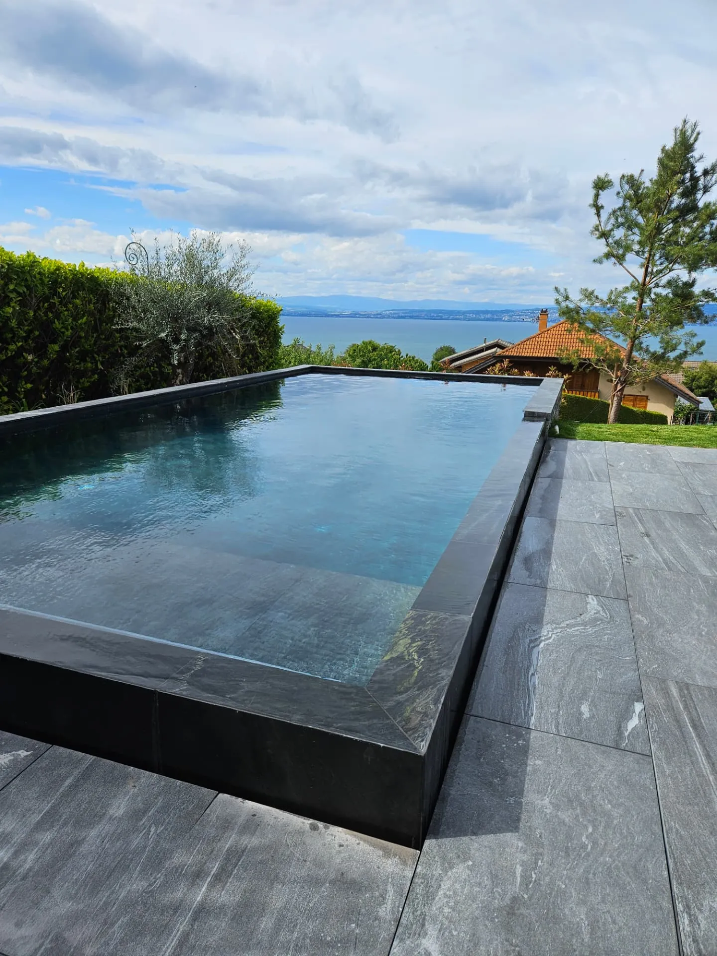 Piscine à débordement et dallage gris face au lac Léman – Neuvecelle