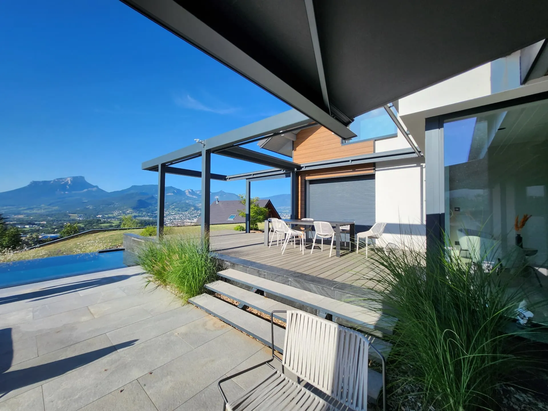 Terrasse en bois et dallage sous pergola, graminées et vue sur la vallée – Saint-Alban-Leysse