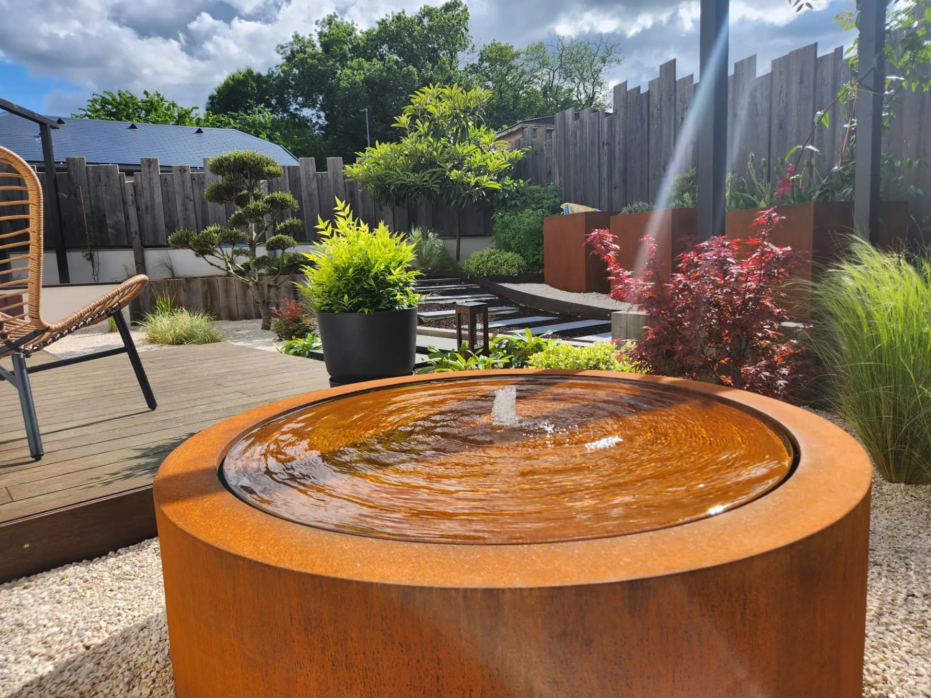 Fontaine en acier corten au pied d'une terrasse en bois – La Motte-Servolex