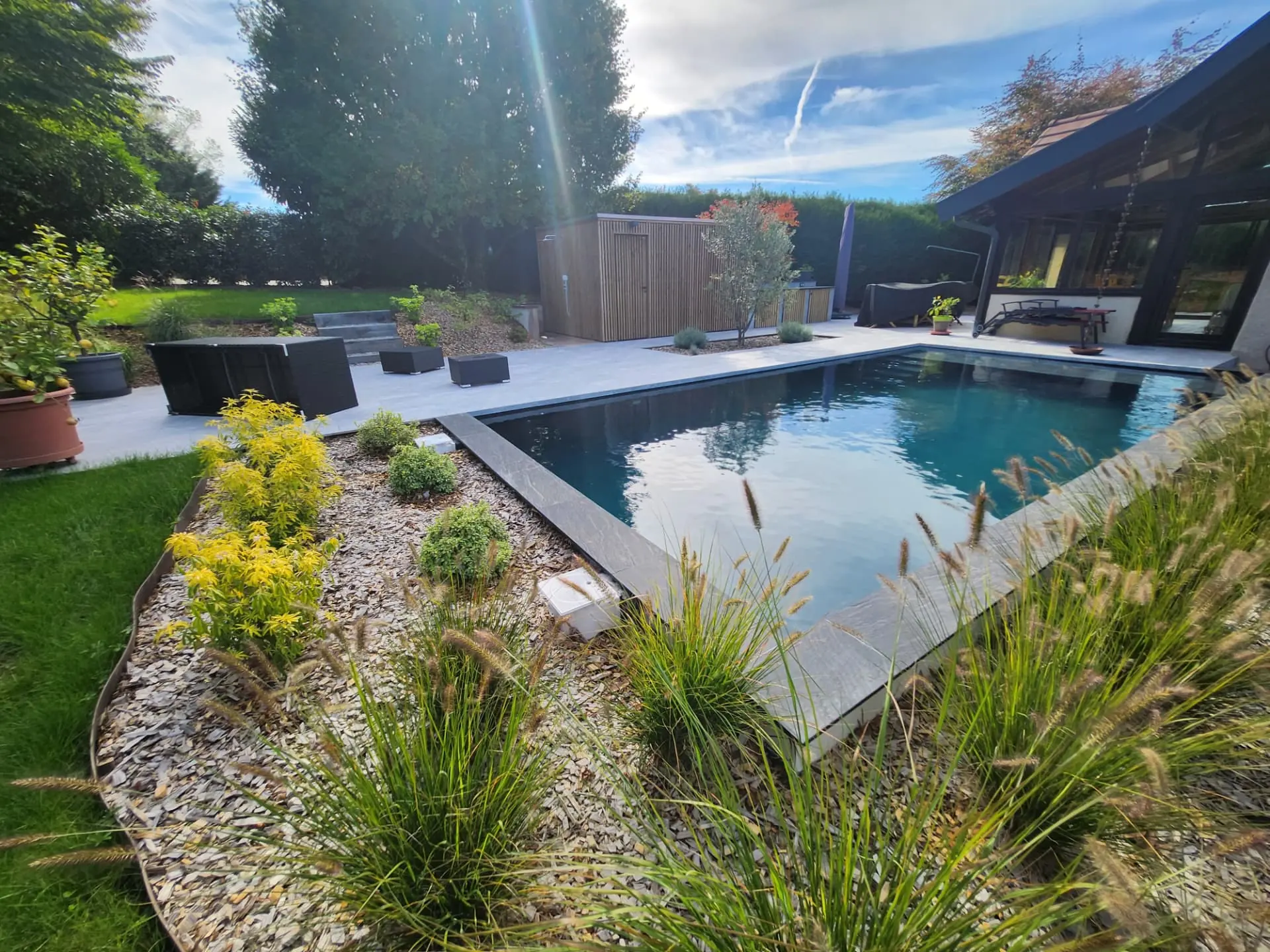 Piscine bordée de graminées et de massifs sur paillage minéral – Annecy-le-Vieux