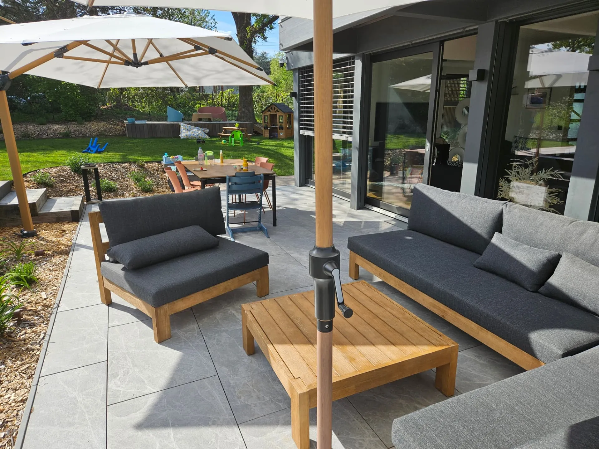 Salon de jardin sous parasol sur une terrasse en dallage clair – Seynod