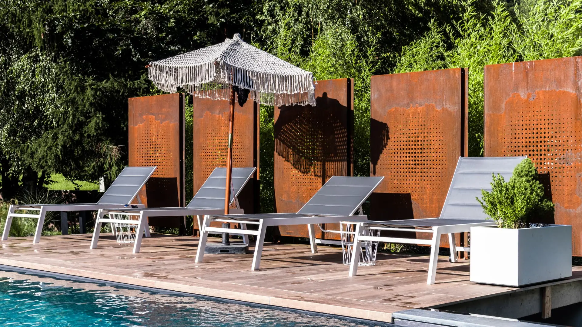 Bains de soleil sur terrasse en bois devant des panneaux en acier corten – Bonneville