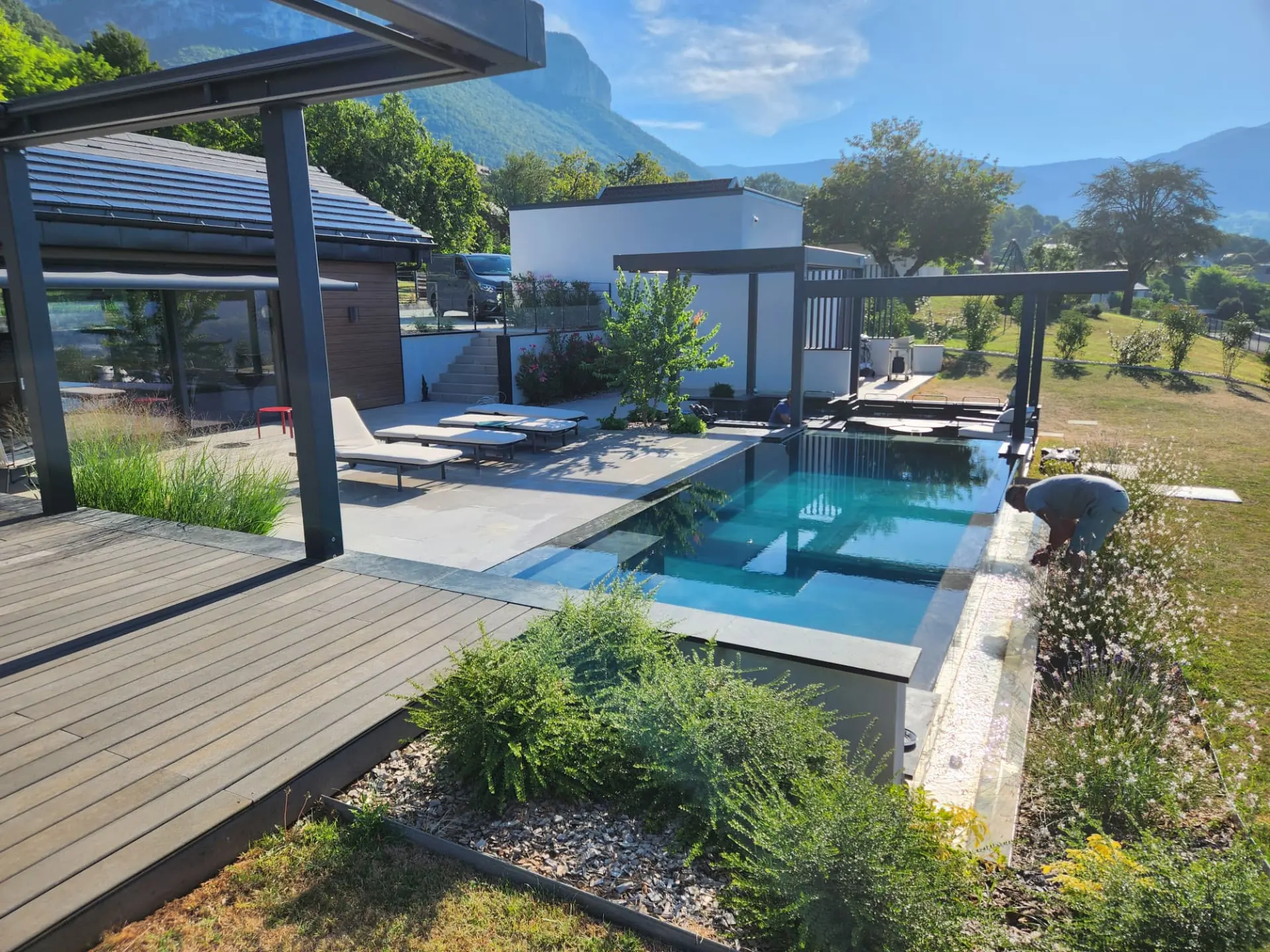 Piscine bordée d'une terrasse en bois et de massifs de graminées – Saint-Alban-Leysse