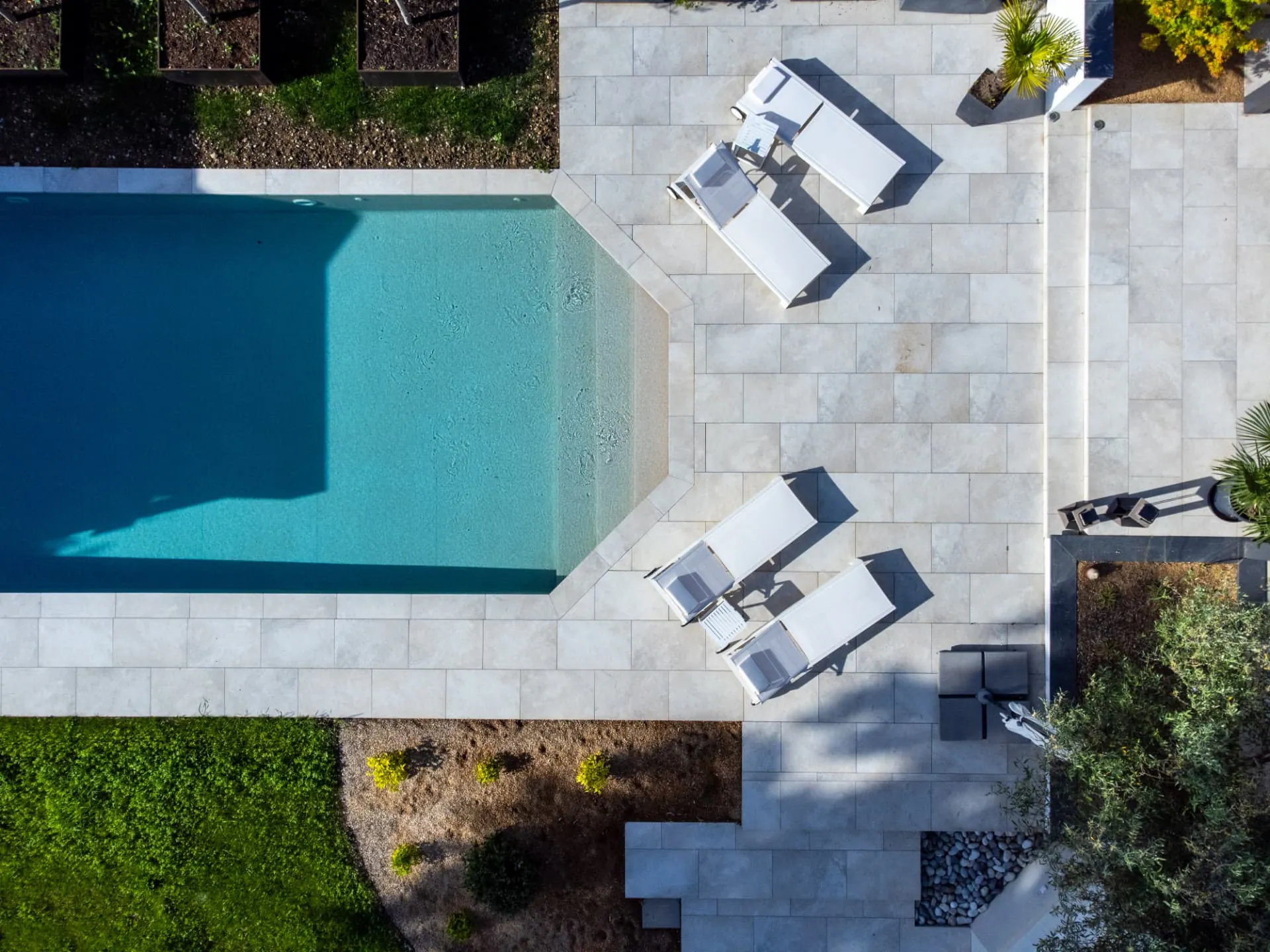 Vue aérienne de la piscine, du dallage clair et des bains de soleil – Rumilly