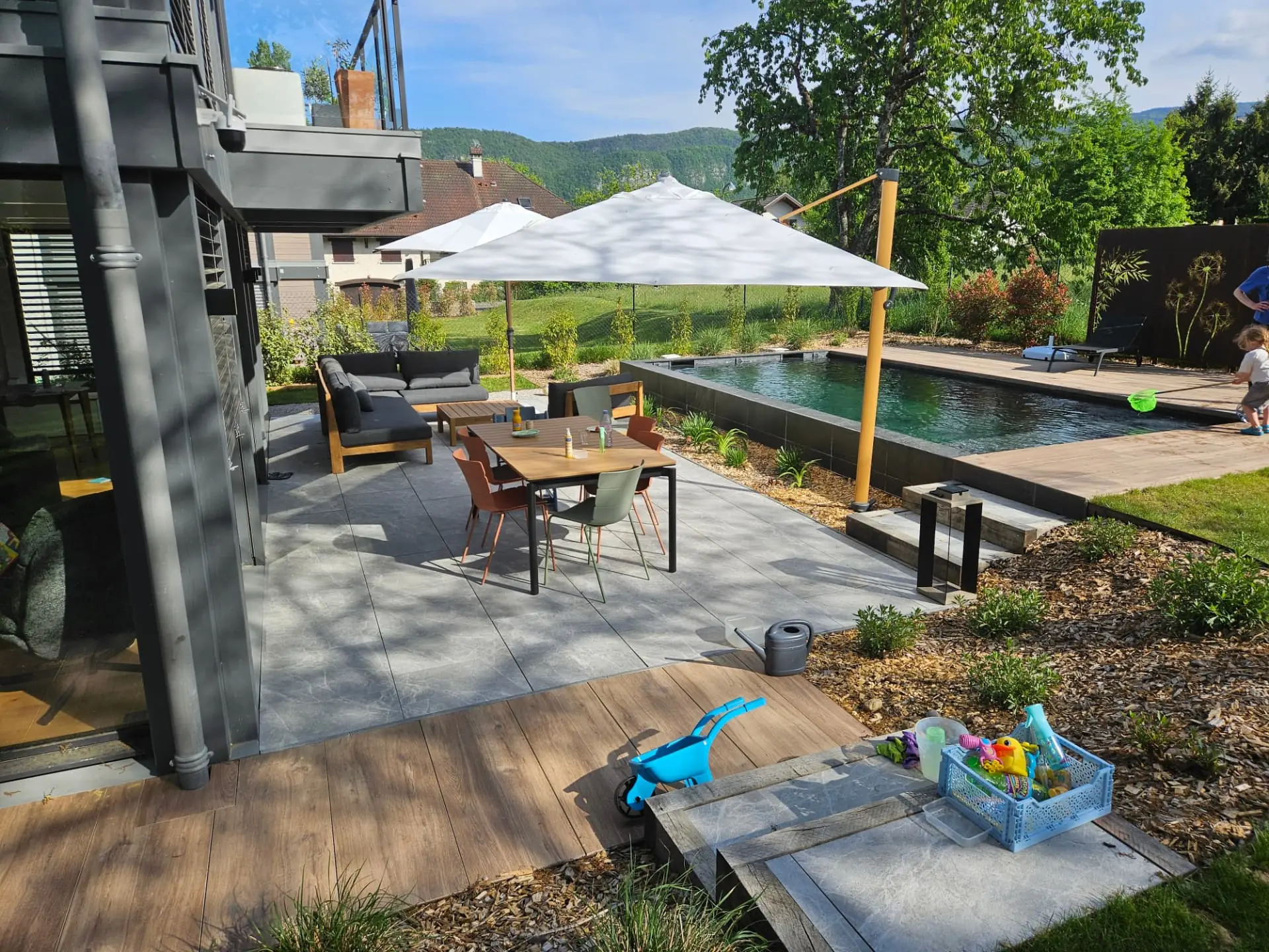 Terrasse en dallage et en bois reliant la maison, la piscine et le jardin – Seynod