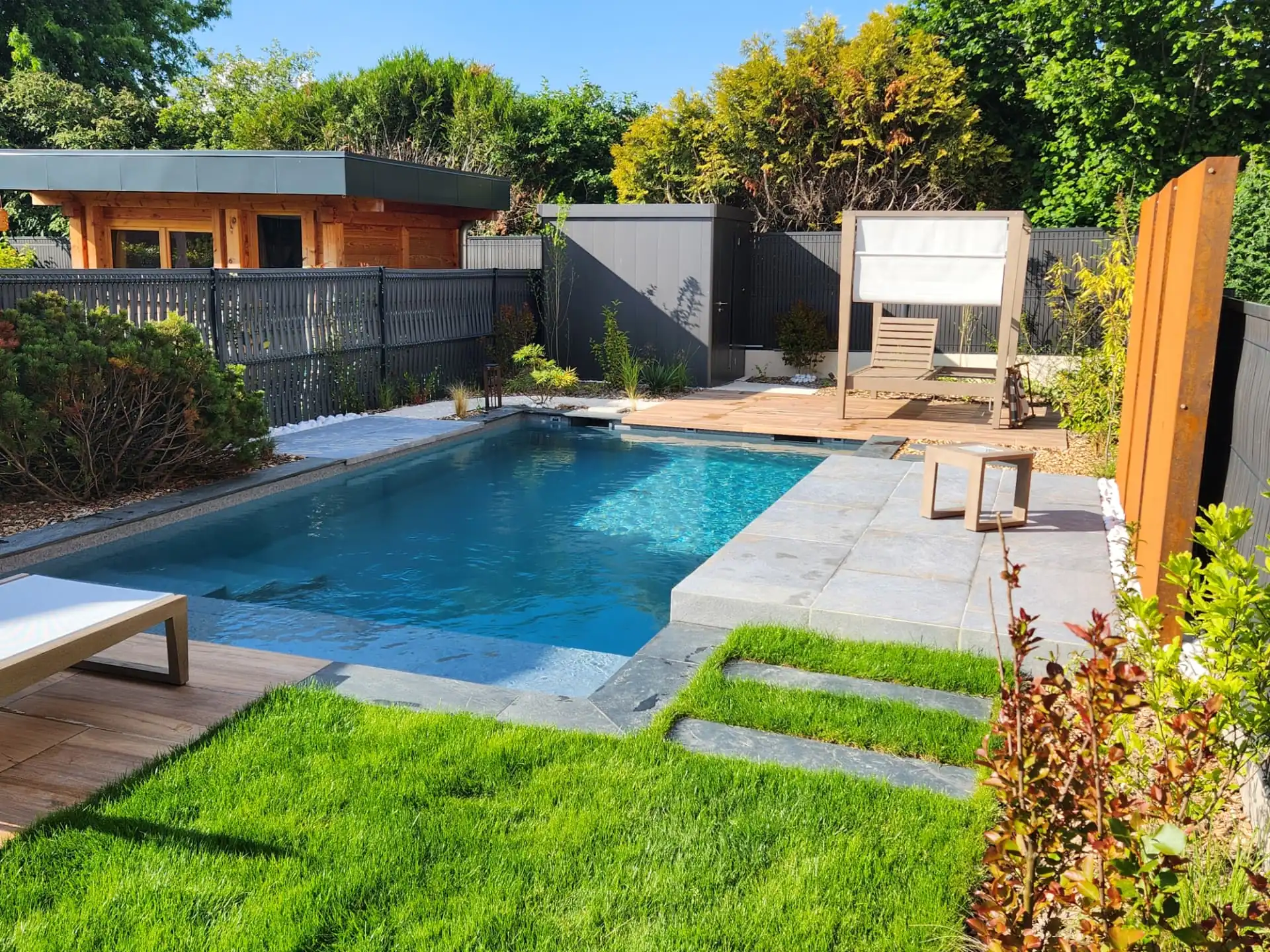 Piscine entourée de pelouse et de pas japonais, pool house en bois – Saint-Julien-en-Genevois