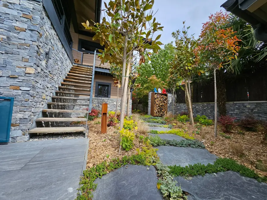 Pas japonais en pierre, arbres et massifs au pied d'un escalier extérieur – Neuvecelle