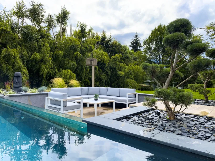 Salon extérieur au bord de la piscine, arbre taillé en nuage et paillage d'ardoise – Bonneville