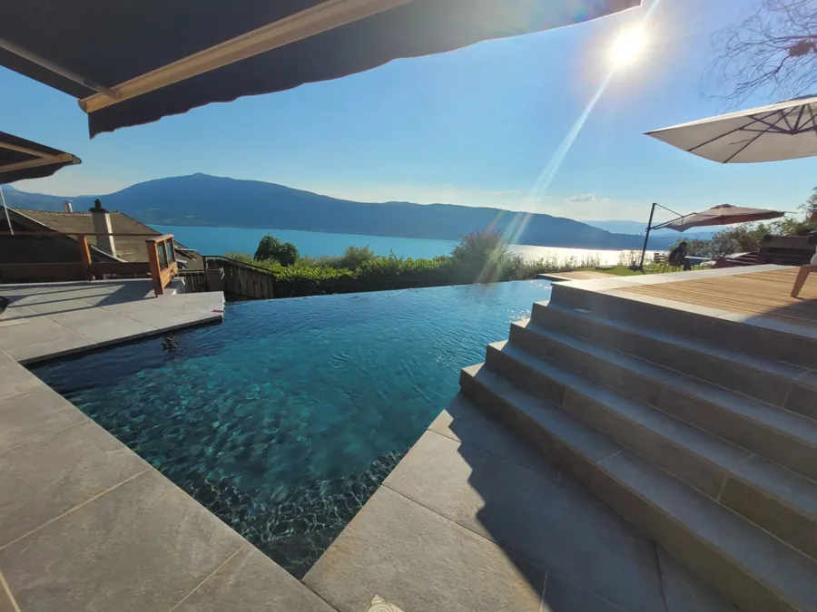 Piscine à débordement et escalier en dallage face au lac – Veyrier-du-Lac